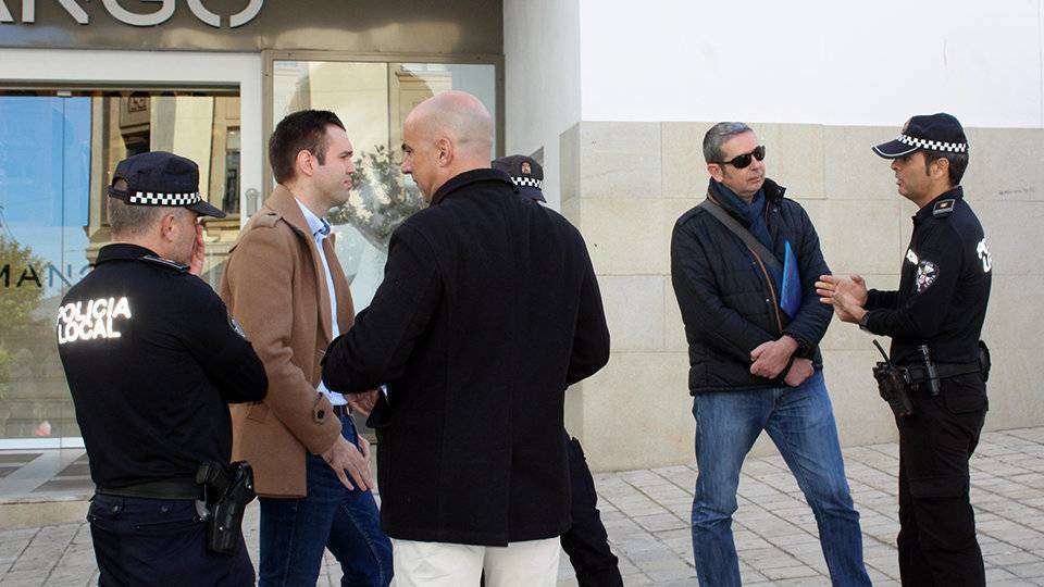 El coordinador de campaña de Vox, Carlos Verdejo (izquierda, y el gerente del PP, Javier Martí, conversan con los policías locales en la ubicación disputada por los dos partidos (C.A.)