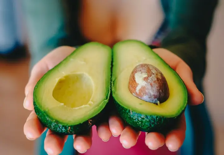 Mujer mostrando un aguacate. Pixabay.