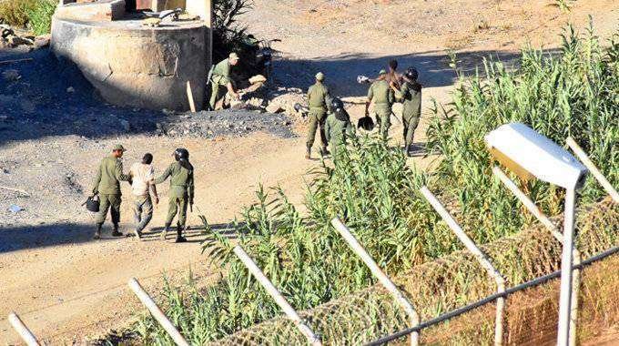 Fuerzas de seguridad marroquíes conducen a migrantes que trataban de franquear la valla (C.A./ARCHIVO)