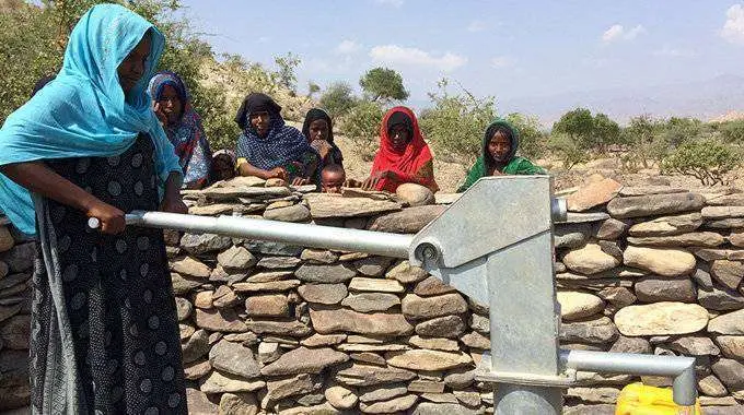 Una mujer extrae agua de un pozo en Afar (Etiop&iacute;a) (CEDIDA)