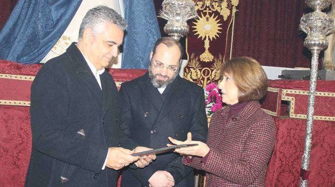 Bautista recoge las guardas de mano de la presidenta del Consejo de Hermandades y Cofradías (J. CHELLARAM)