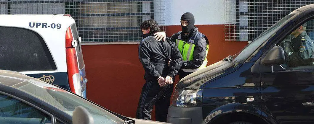 Un agente conduce a un detenido en una operaci&oacute;n antiterrorista desarrollada en Ceuta en2016 (C.A./ARCHIVO)