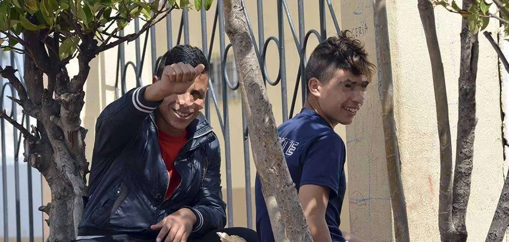 Dos menores extranjeros saludan a la c&aacute;mara en las inmediaciones del recinto portuario (C.A./ARCHIVO)