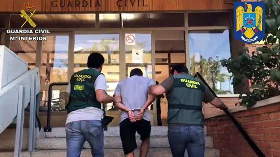 El detenido es conducido por dos agentes (GUARDIA CIVIL)