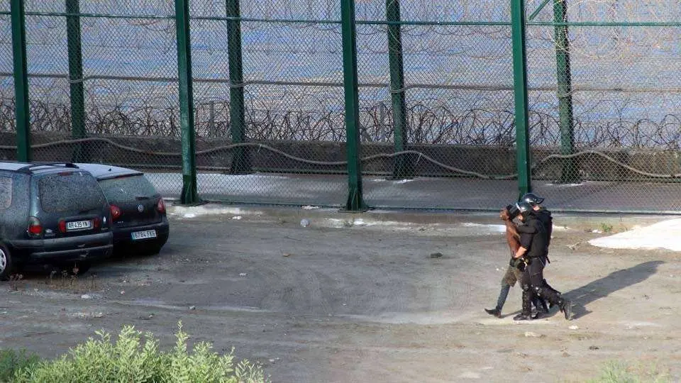Dos guardias civiles conducen a uno de los migrantes devueltos a Marruecos el viernes (C.A.)