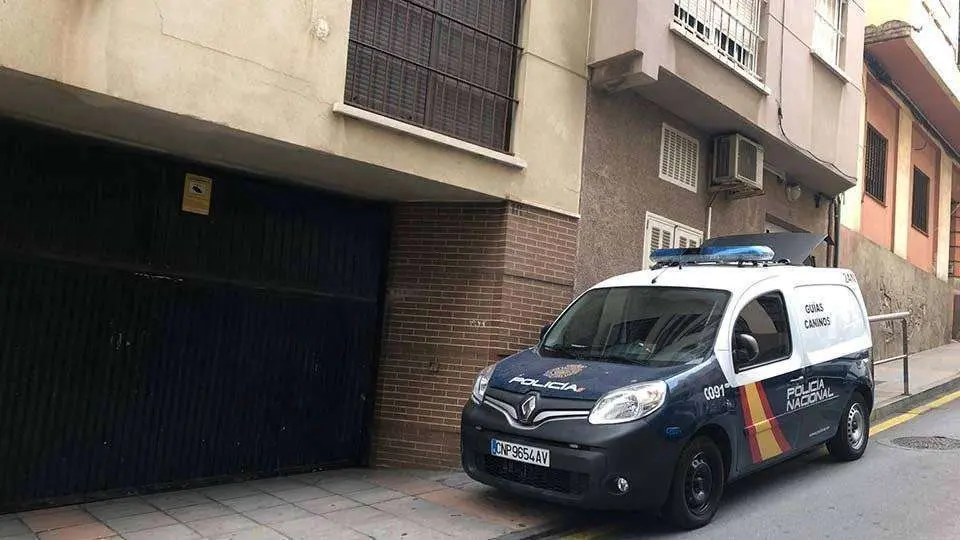 Un veh&iacute;culo policial de la unidad de Gu&iacute;as Caninos, a la puerta del inmueble donde se encuentra la vivienda registrada (C.A.)