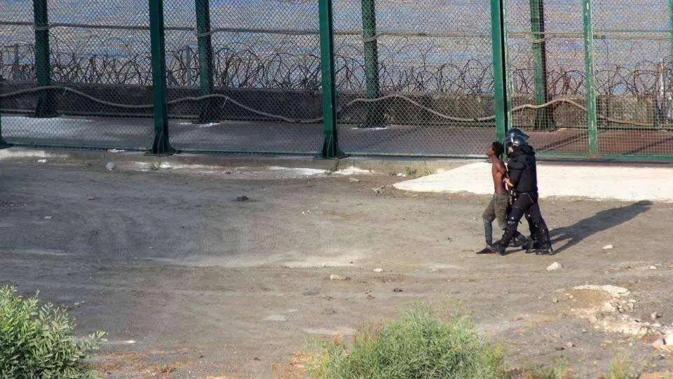 Dos guardias civiles conducen a un subsahariano hacia el lado de la frontera marroqu&iacute; el 30 de agosto del pasado a&ntilde;o (C.A./ARCHIVO)