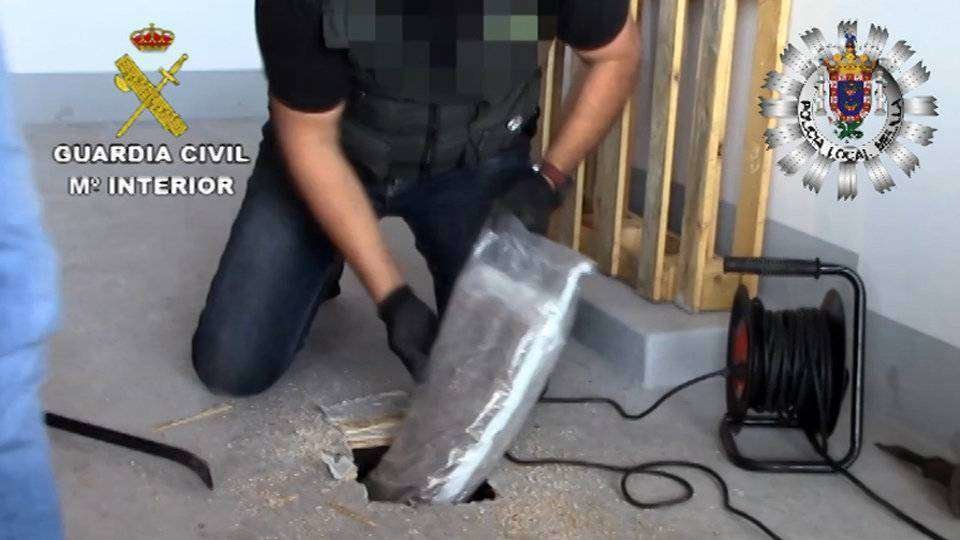 Un guardia civil recupera un paquete de droga hallado en uno de los registros (GUARDIA CIVIL)