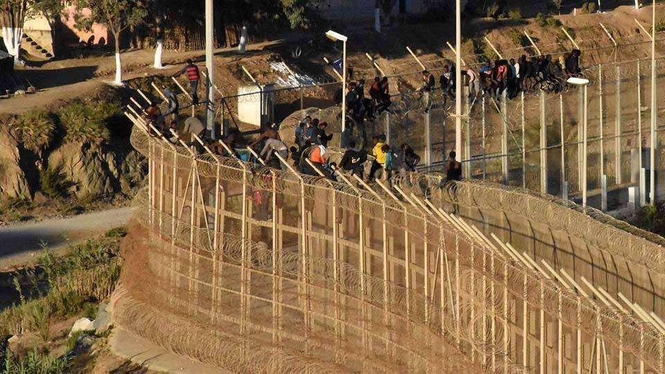 Migrantes, encaramados a la valla de Ceuta (C.A./ARCHIVO)