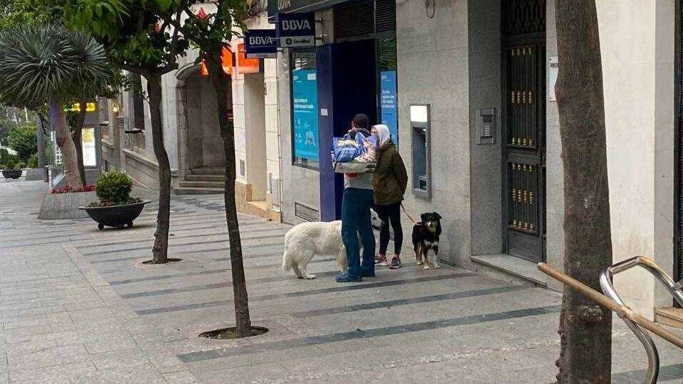 Dos viandantes pasean a sus perros por el centro de la ciudad (C.A.)