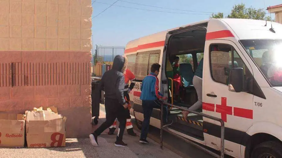 Menores suben a un veh&iacute;culo de la Cruz Roja para su traslado a la Jefatura de la Polic&iacute;a Nacional (J. CHELLARAM)