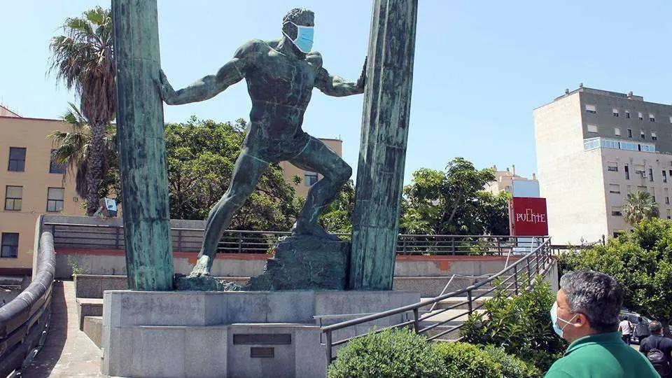 El rostro de la estatua de H&eacute;rcules, cubierto por una mascarilla (J. CHELLARAM)