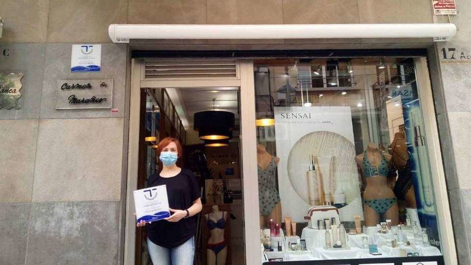 Una empresaria posa con el distintivo SICTED a las puertas de su establecimiento (CEDIDA)