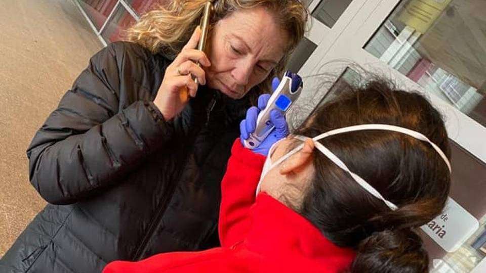 Una voluntaria de Cruz Roja toma la temperatura a una mujer a la entrada del Hospital Universitario (C.A./ARCHIVO)