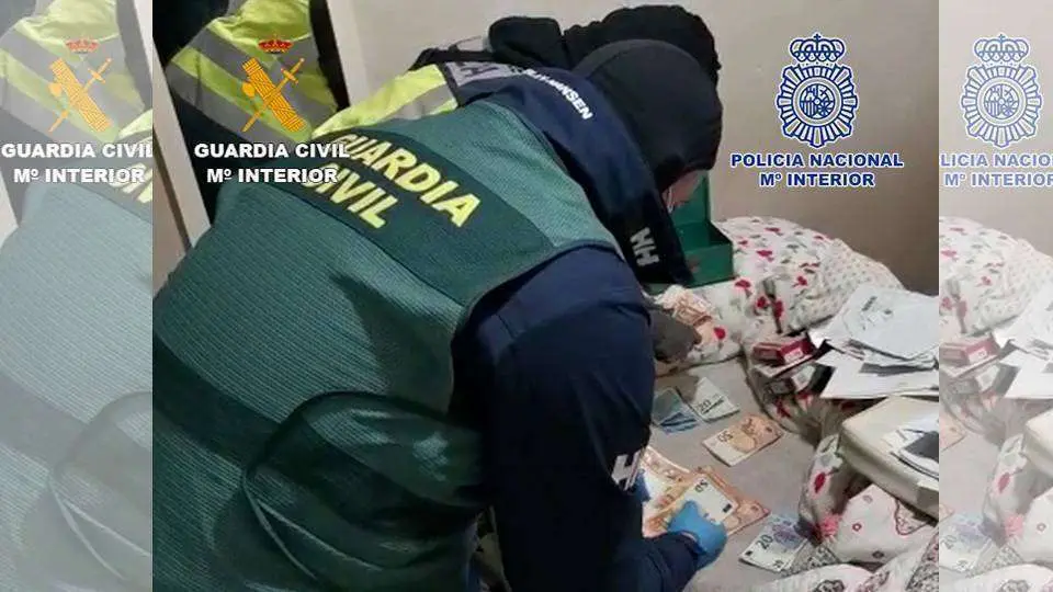 Agentes de la Guardia Civil cuentan el dinero incautado en el transcurso de la operaci&oacute;n (MINISTERIO DEL INTERIOR)