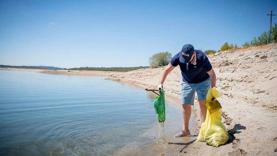 Un hombre recoge residuos en una playa