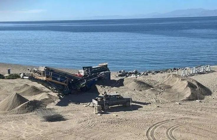 Excavadoras regenerando la arena en la playa de la Ribera, en Ceuta