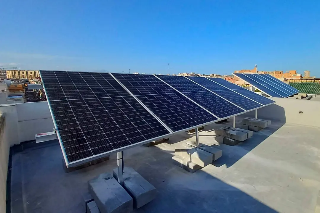 Aerial view of many photo voltaic solar panels mounted of industrial building roof.