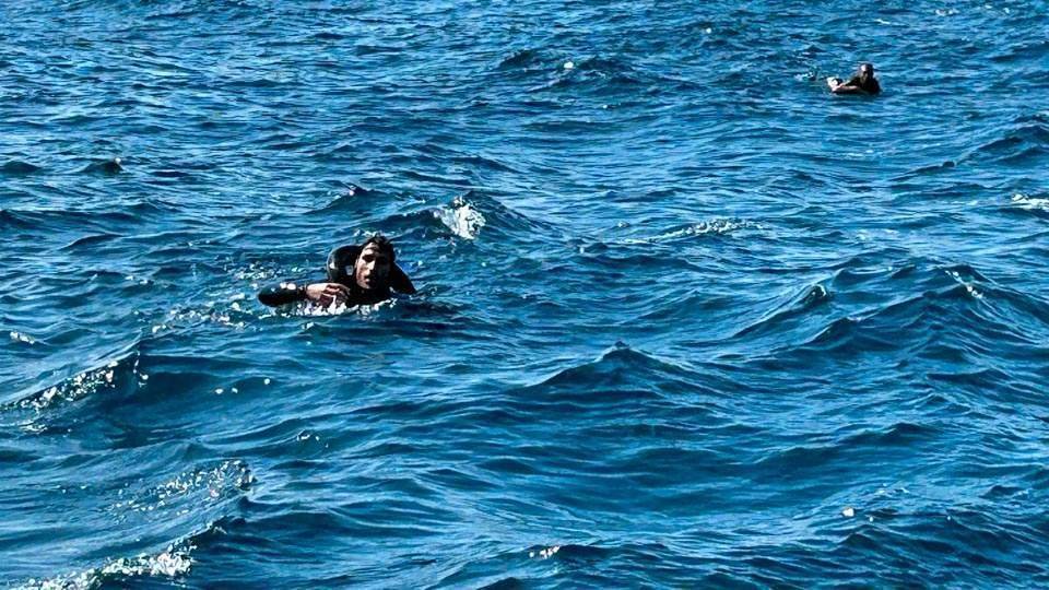 Dos migrantes tratan de mantenerse a flota mientras nadan para ganar la costa de Ceuta