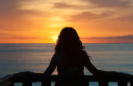 34365900-chica-de-espaldas-de-pie-en-un-balc&oacute;n-frente-al-mar-y-mirando-la-salida-del-sol