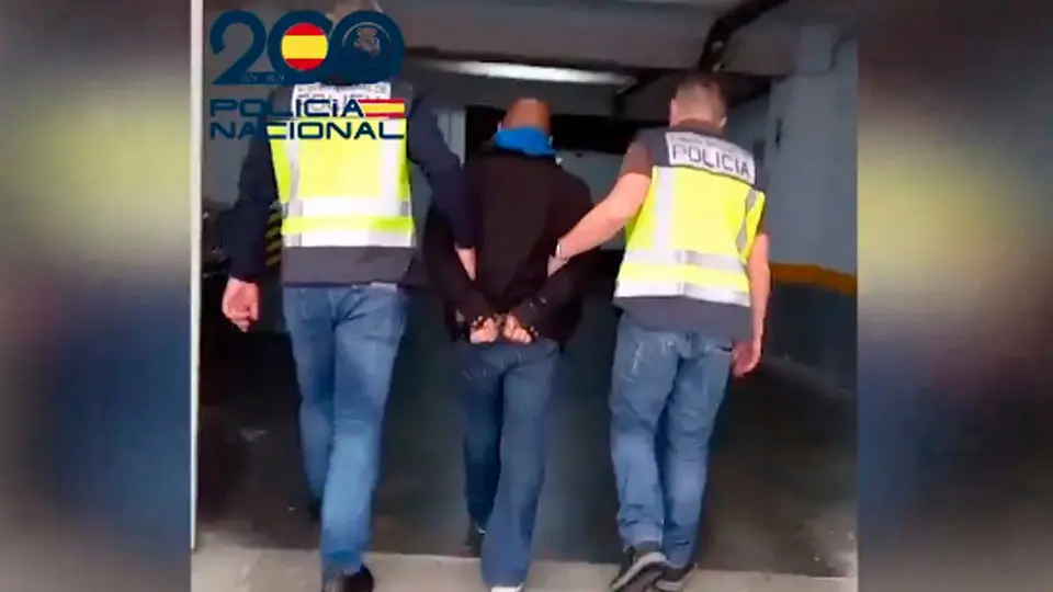 El detenido, conducido por dos agentes (POLIC&Iacute;A NACIONAL)