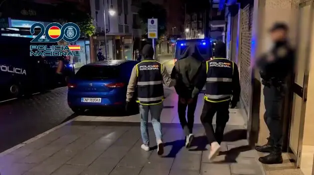 Dos agentes conducen a uno de los detenidos (POLIC&Iacute;A NACIONAL)