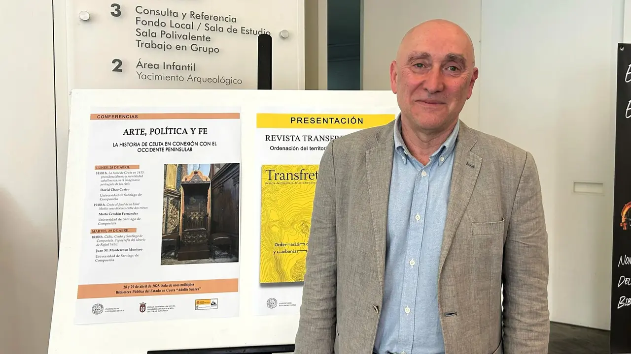 Juan M. Monterroso Monteor, junto al cartel de las jornadas de arte, pol&iacute;tica y fe, del IEC