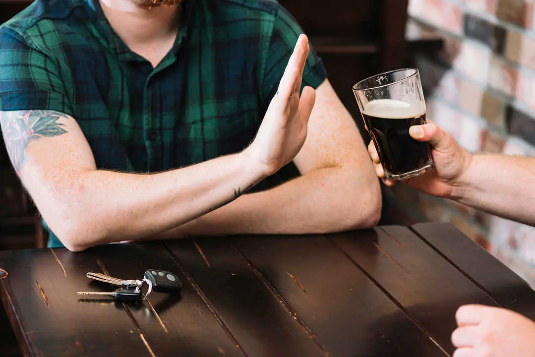 hombre rechazando vaso de alcohol