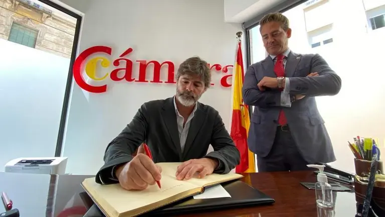  Basilio Mart&iacute;nez firmando en el libro de honor de la C&aacute;mara en presencia de Karim Bulaix. 