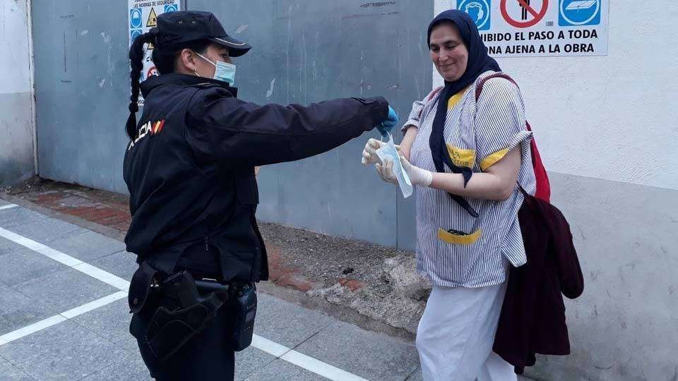 Una agente de Policía entrega una mascarilla a una viandante (C.A./ARCHIVO)