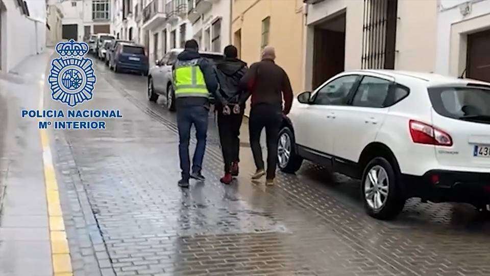 Dos policías conducen al detenido por las calles de Estepa (POLICÍA NACIONAL)