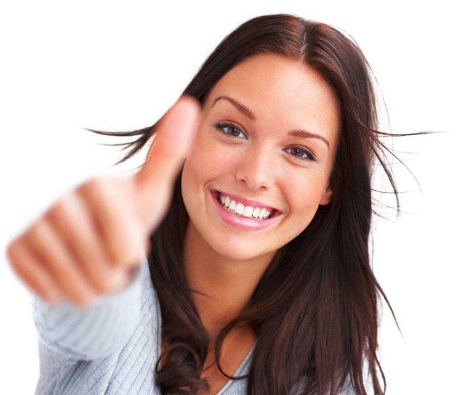Portrait of attractive young woman showing a thumbs up on white background