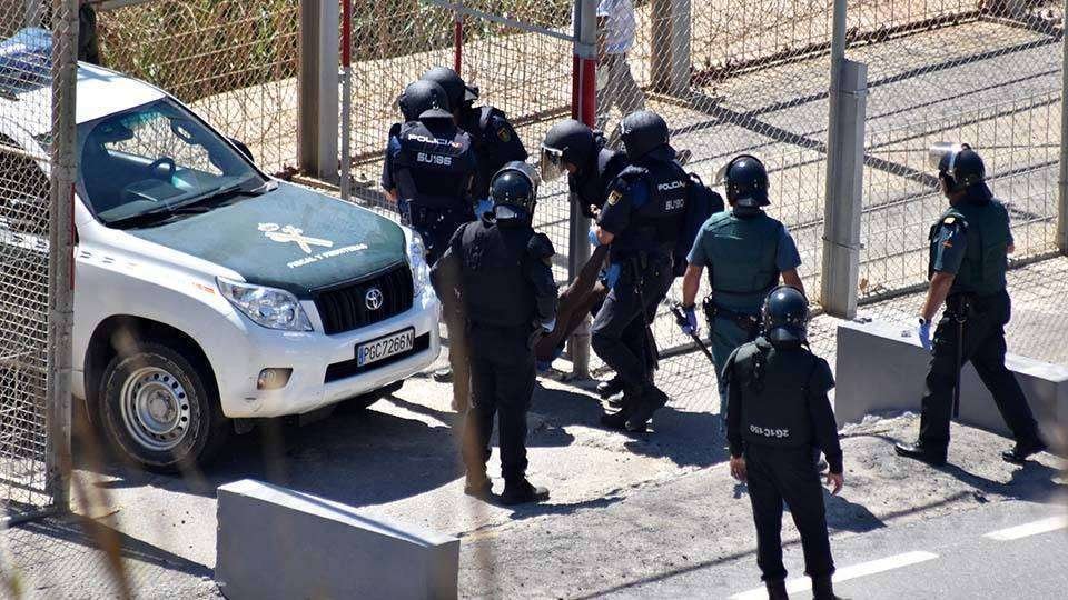 Agentes de la Policía Nacional y la Guardia Civil devuelven a un migrante a pie de valla (C.A./ARCHIVO)