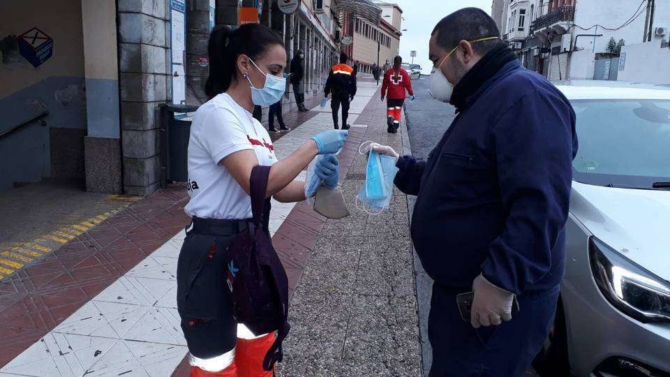 Una voluntaria de Cruz Roja reparte mascarillas junto al Mercado Central (CEDIDA)