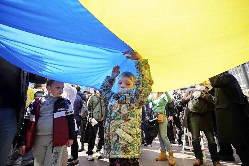 Tokyo (Japan), 26/02/2022.- A young boy stands under a large national flag of Ukraine during a protest against Russia's invasion of Ukraine, in Tokyo, Japan, 26 February 2022. Russian troops entered Ukraine on 24 February prompting the country's president to declare martial law and triggering a series of announcements by G7 countries to impose severe economic sanctions on Russia. (Protestas, Japón, Rusia, Ucrania, Tokio) EFE/EPA/FRANCK ROBICHON
