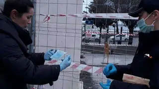 Una agente de Polic&iacute;a entrega una mascarilla a una viandante