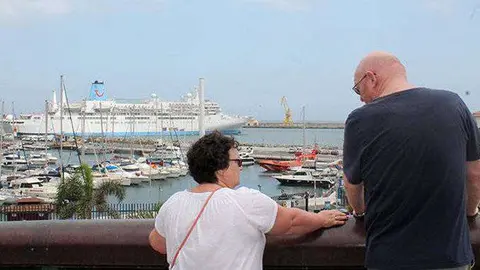 Dos turistas charlan frente al crucero que les ha tra&iacute;do a la ciudad (C.A./ARCHIVO)