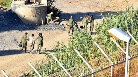Fuerzas de seguridad marroqu&iacute;es conducen a migrantes que trataban de franquear la valla (C.A./ARCHIVO)
