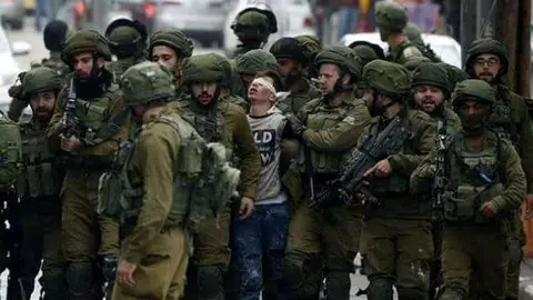 Militares israel&iacute;es conducen a un detenido (E.D.)
