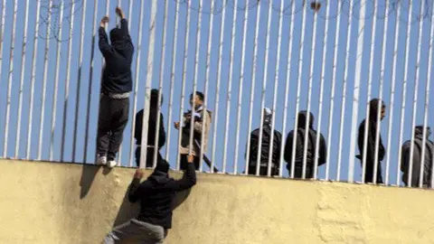 Menores trepan por una valla que delimita las instalaciones portuarias (C.A./ARCHIVO)