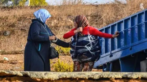 Una mujer ayuda a otra a ocultar mercanc&iacute;a adherida al cuerpo, ayer junto ala frontera (C.A.)