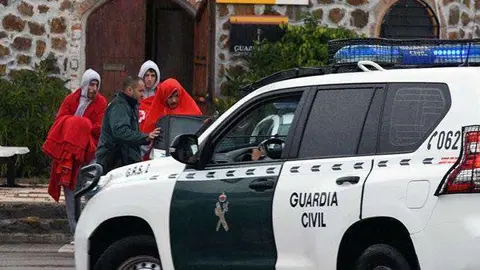 Los migrantes, acompa&ntilde;ados de un Guardia Civil en el puerto deportivo (C.A.)