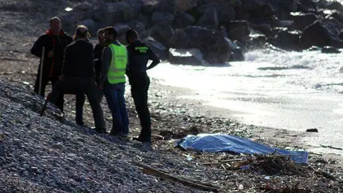 Miembros de la Guardia Civil junto al cuerpo del migrante fallecido (C.A.)