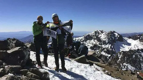 Pozo, junto a sus compa&ntilde;eros de expedici&oacute;n, despliega una bandera de Ceuta en la cima (CEDIDA)