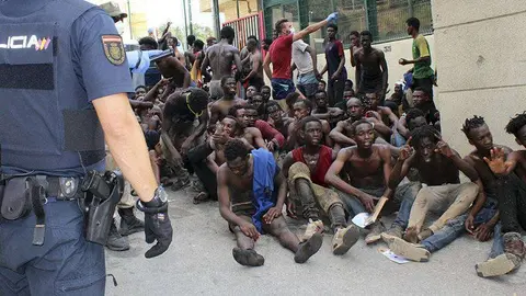 Un grupo de migrantes se concentra a las puertas del CETI tras saltar la valla fronteriza el pasado agosto (C.A./ARCHIVO)