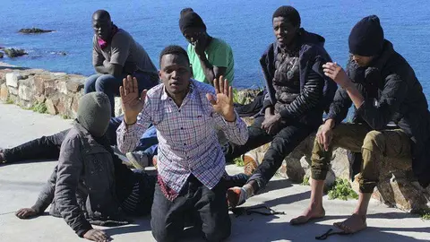 Un grupo de j&oacute;venes aguardan a ser conducidos al CETI tras alcanzar la costa de Ceuta en una patera (C.A./ARCHIVO)