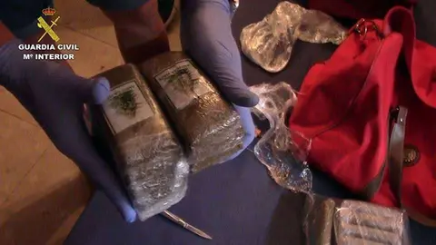 Un agente muestra parte de la droga incautada (GUARDIA CIVIL)