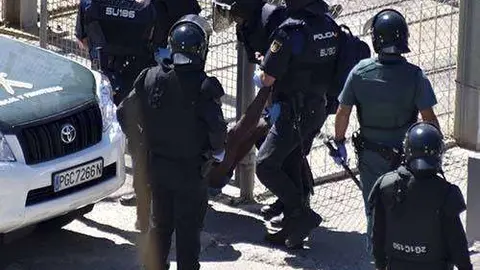 Agentes de la Polic&iacute;a Nacional y la Guardia Civil devuelven a un migrante a pie de valla (C.A./ARCHIVO)