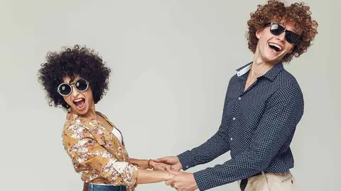 Picture of young emotional happy retro loving couple standing and posing isolated. Looking camera dancing.