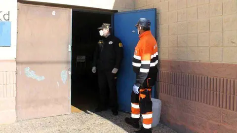 Un polic&iacute;a y un voluntario de Protecci&oacute;n Civil, en uno de los acceso al pabell&oacute;n La Libertad (J. CHELLARAM)